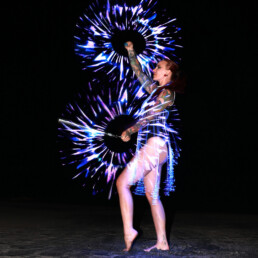 LED performer creating a dynamic light-based live performance with illuminated costume and props
