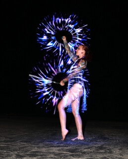 LED performer creating a dynamic light-based live performance with illuminated costume and props